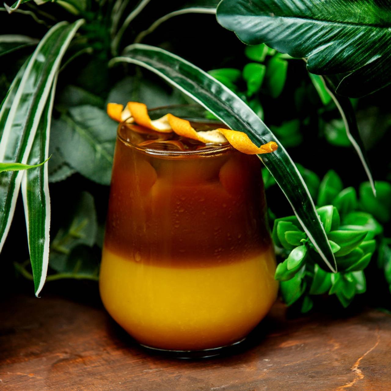 cocktail de laranja em cima da mesa com plantas