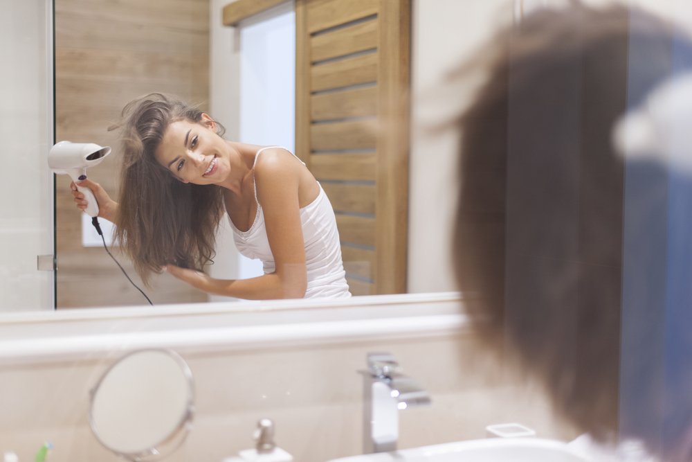 Cabeleireiro seca e modela o cabelo com um secador de cabelo no salão de  beleza