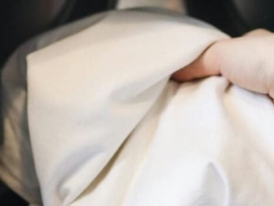 Pessoa colocando roupa branca na máquina de lavar