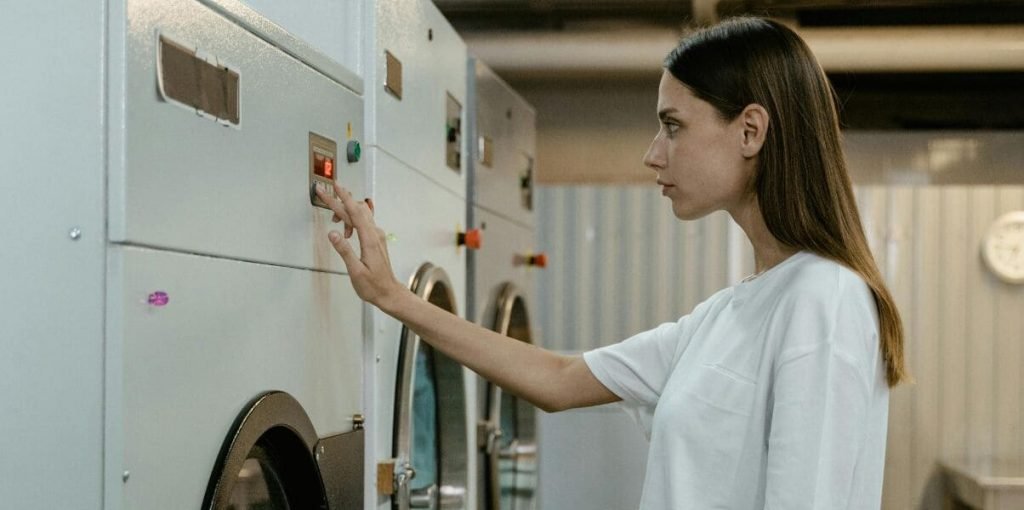 2 Mulher operando máquina de lavanderia