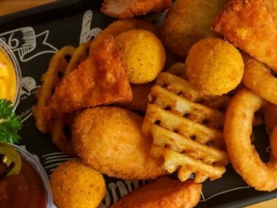 Prato de petiscos variados com molhos e acompanhamentos
