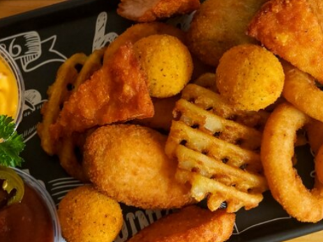 Prato de petiscos variados com molhos e acompanhamentos
