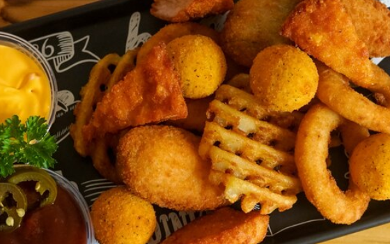 Prato de petiscos variados com molhos e acompanhamentos