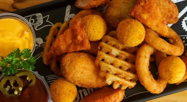 Prato de petiscos variados com molhos e acompanhamentos