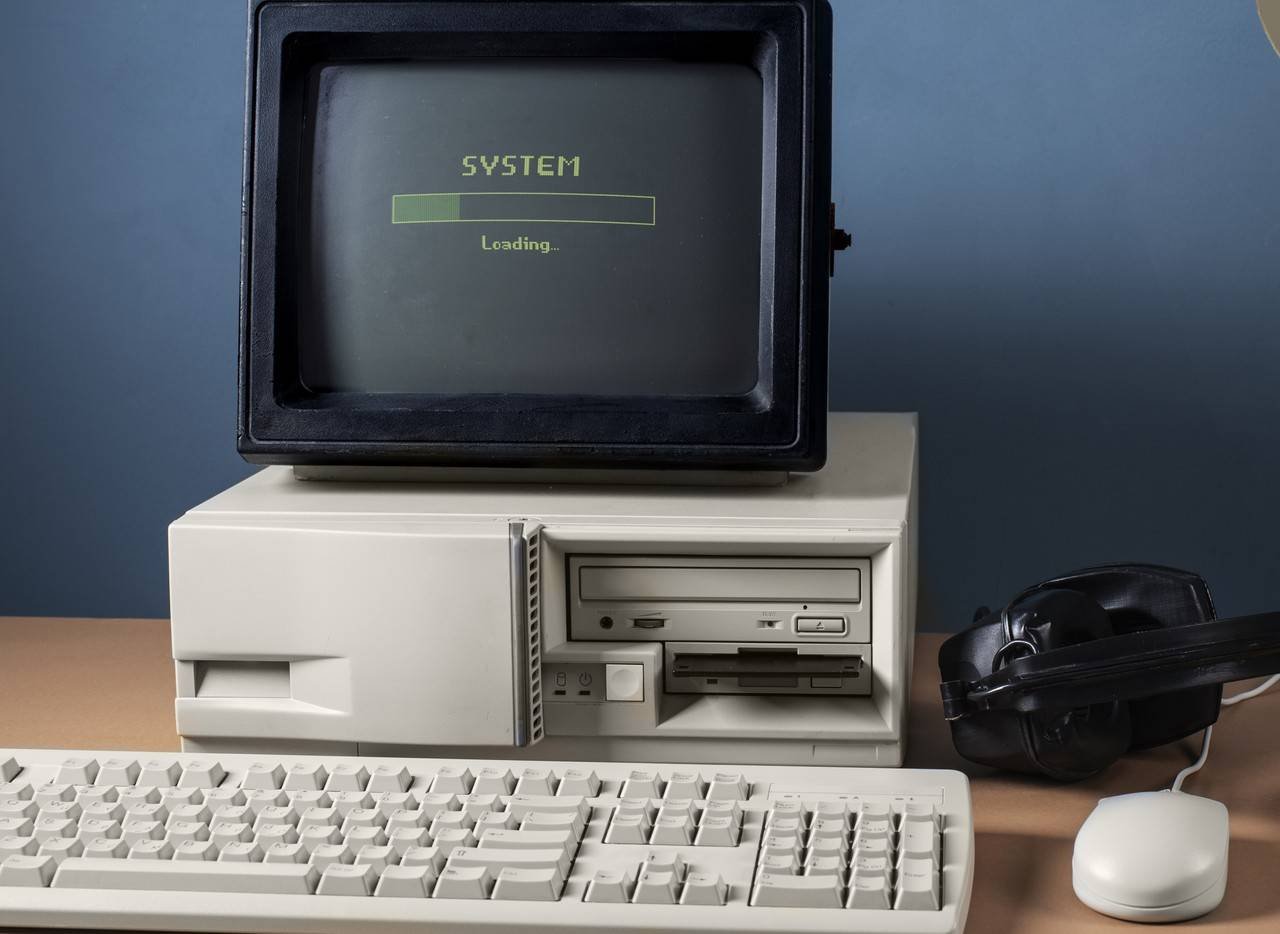 computador retrô com teclado branco e fone preto