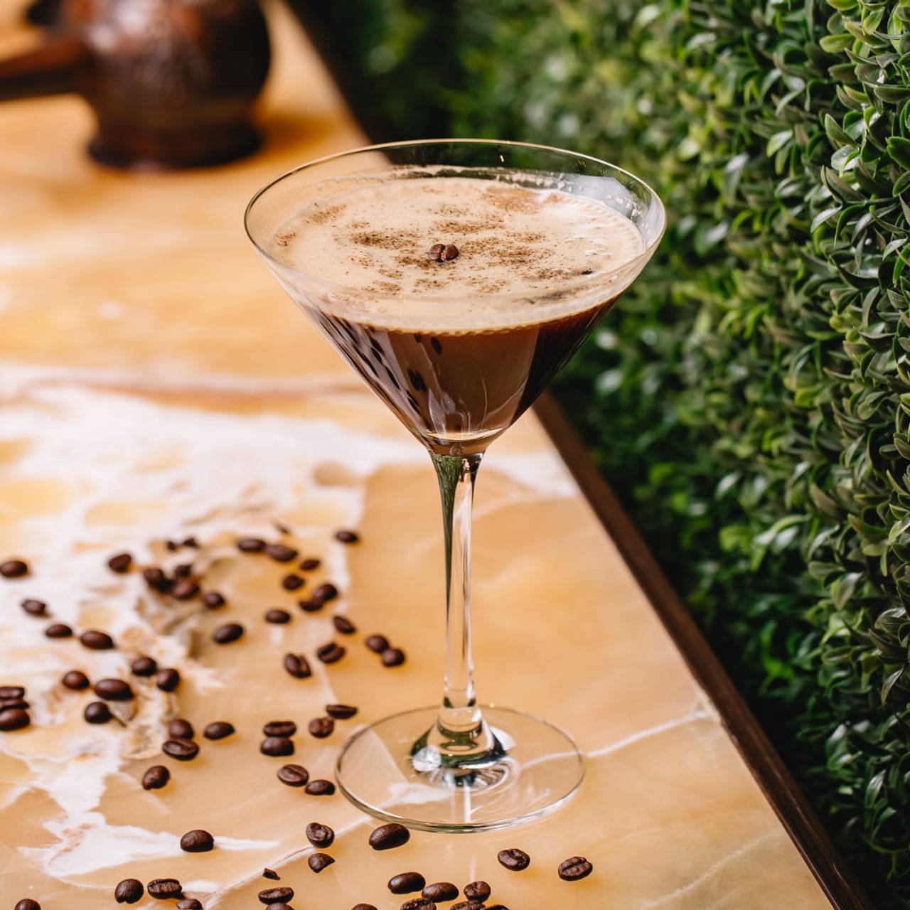 vista lateral do martini de chocolate com canela de especiarias em vidro e graos de cafe na mesa (1)