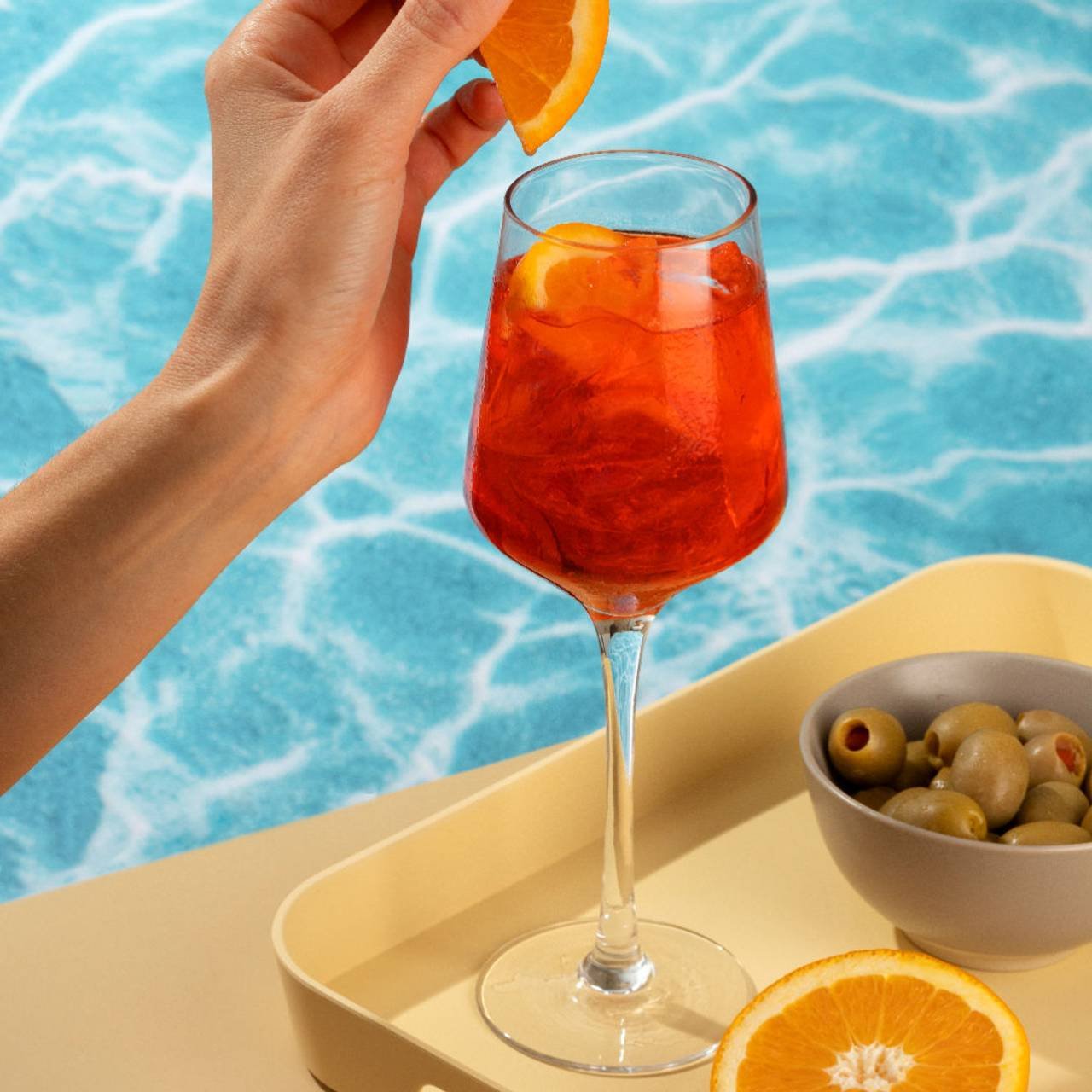 mulher na piscina tomando drink de laranja 