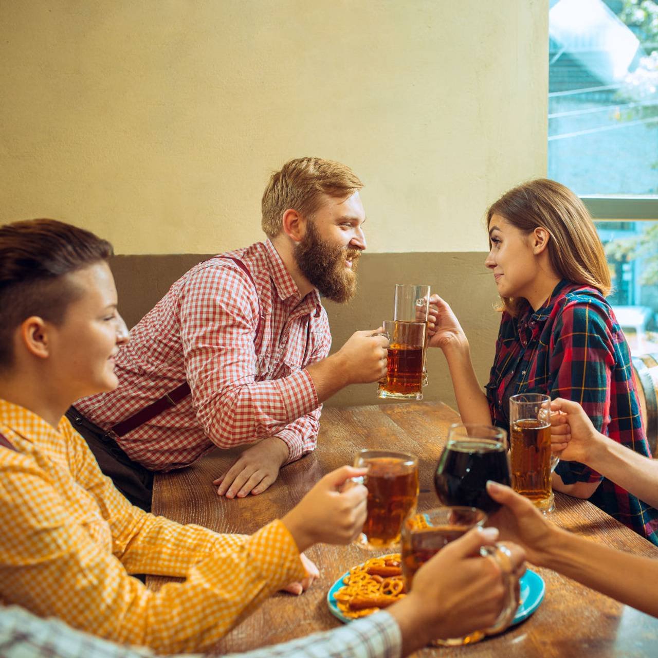 conceito de pessoas lazer amizade e comunicacao amigos felizes bebendo cerveja conversando e tilintar de copos no bar ou pub
