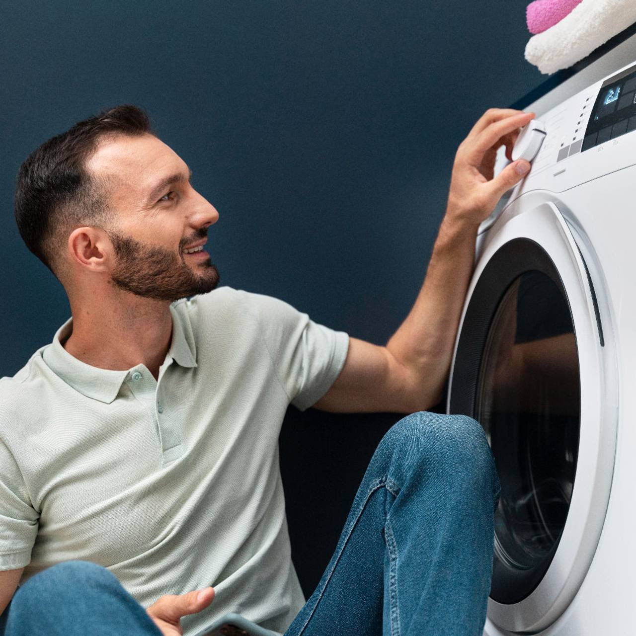 homem esperando a maquina de lavar terminar seu programa 