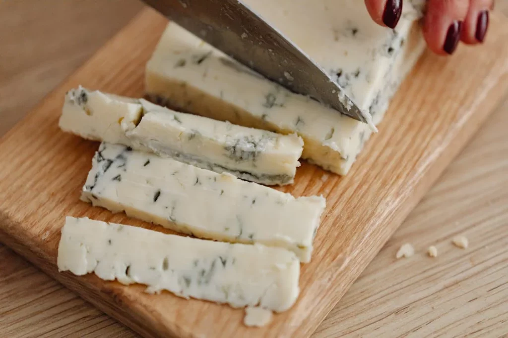 pessoa cortando queijo gorgonzola