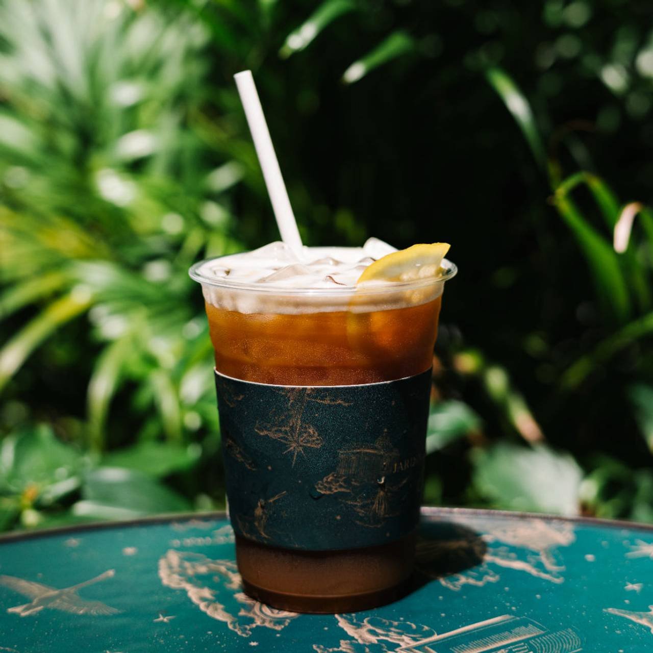 copo de plástico com café gelado dentro e canudo branco