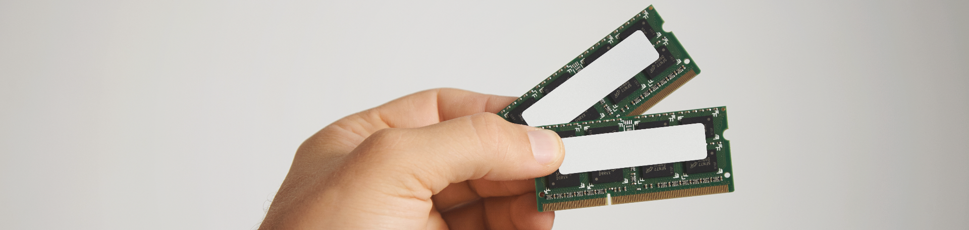 dois chips de ram na mao de um homem isolados no branco