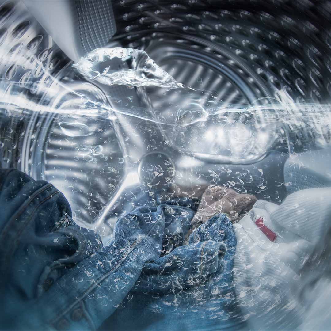 roupas de molho na água dentro da máquina de lavar