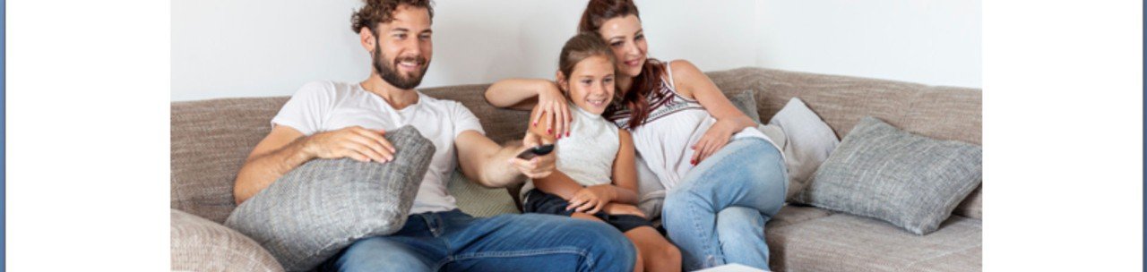 Familia assistindo TV em um sofá cinza