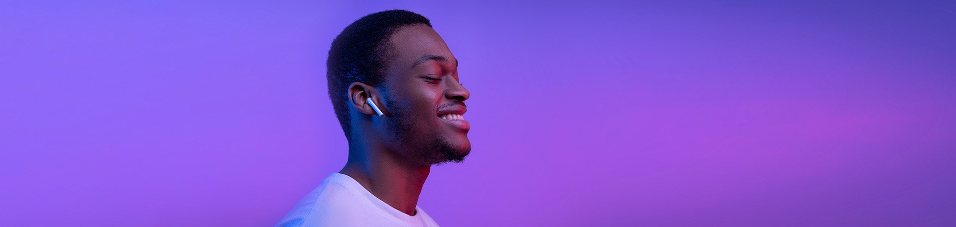 Homem sorridente, de perfil, utilizando headset