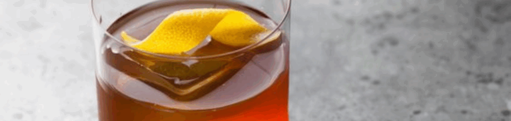 Modelo de Bullets para Simplifica (6) Drink servido com casca de limão em copo de vidro.