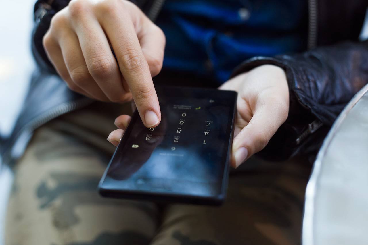 jovem usando seu celular na rua