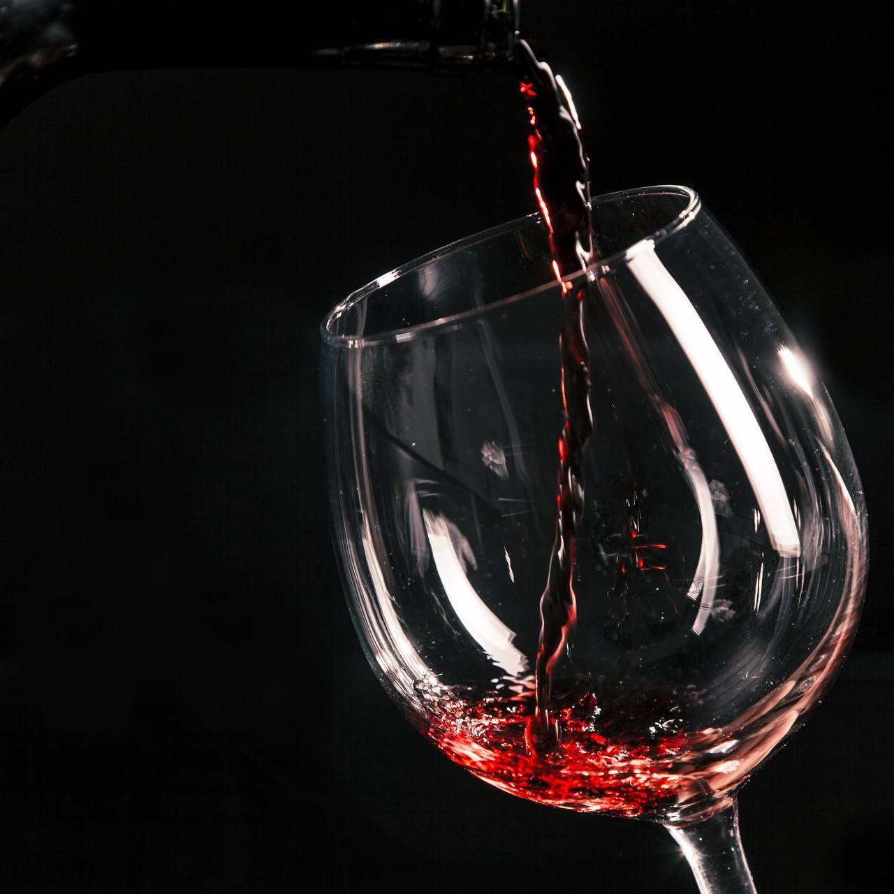 uma taça de vinho sendo preenchida 
