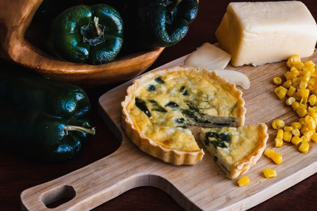 closeup tiro de torta queijo e milho na tabua de cortar e pimentao verde na placa de madeira 181624 35007 Torta de espinafre e milho com pimentões verdes