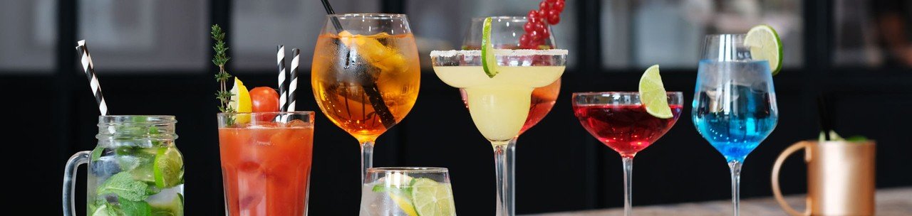 várias taças com drinks feitos com vermute e frutas