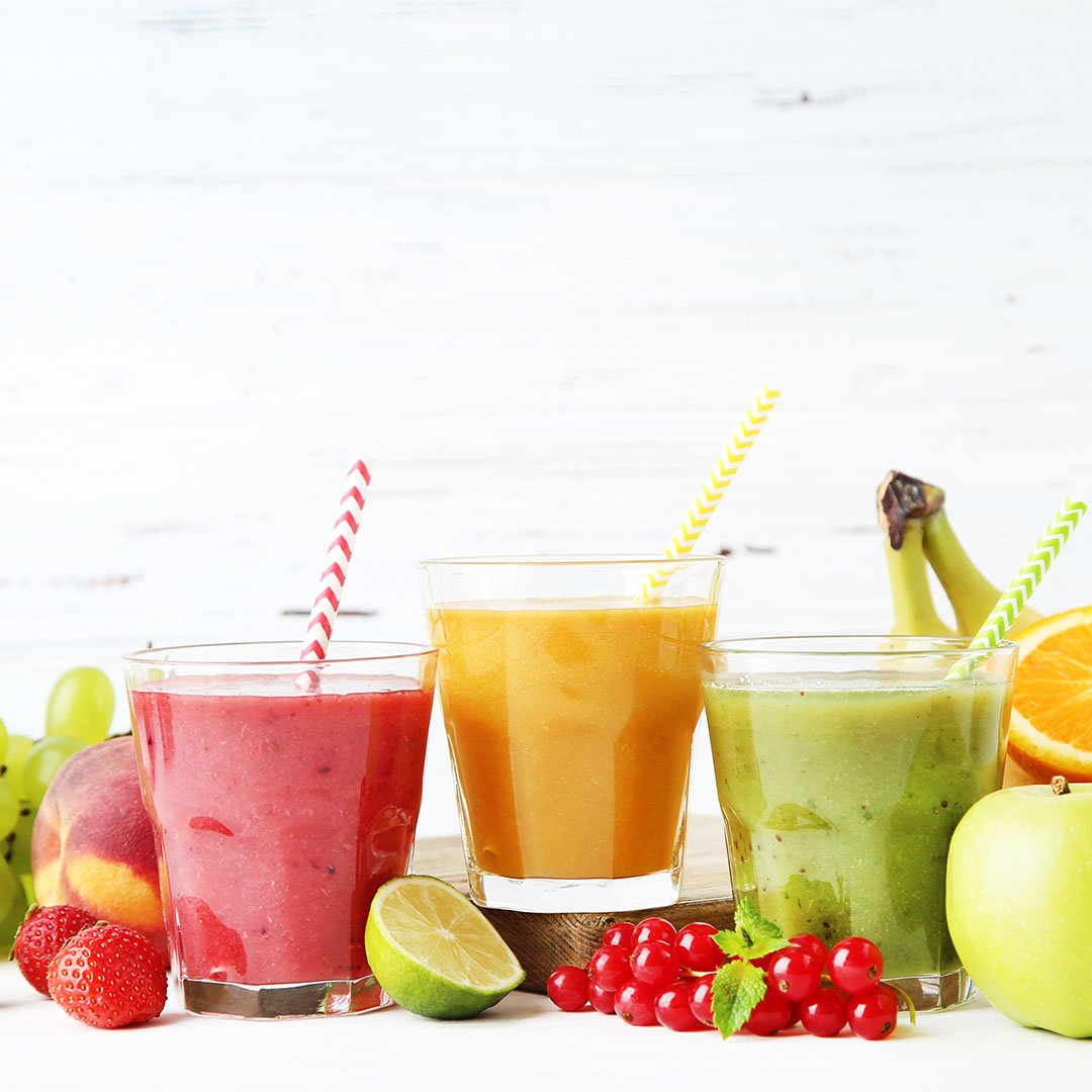 Três copos com batidinhas de diferentes sabores e cores