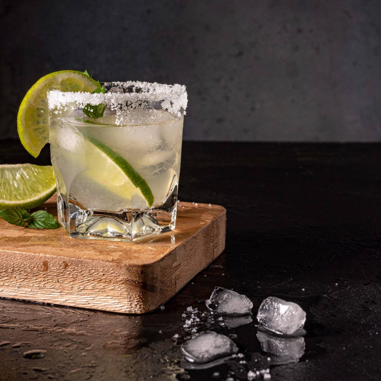 copo de caipirinha de limão com pedaços de limão siciliano e taiti