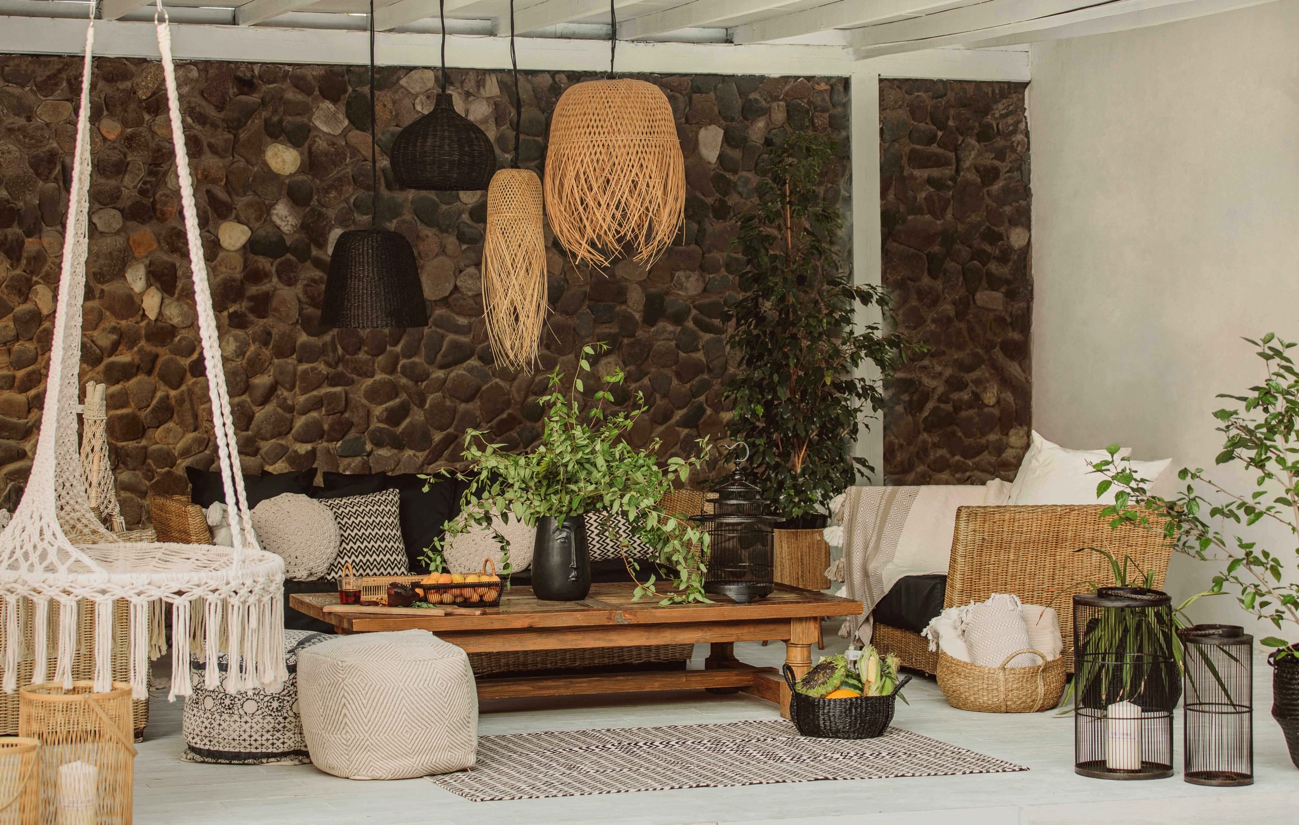 ambiente com estilo boho, balanços de tecido, vasos e tapetes neutros 