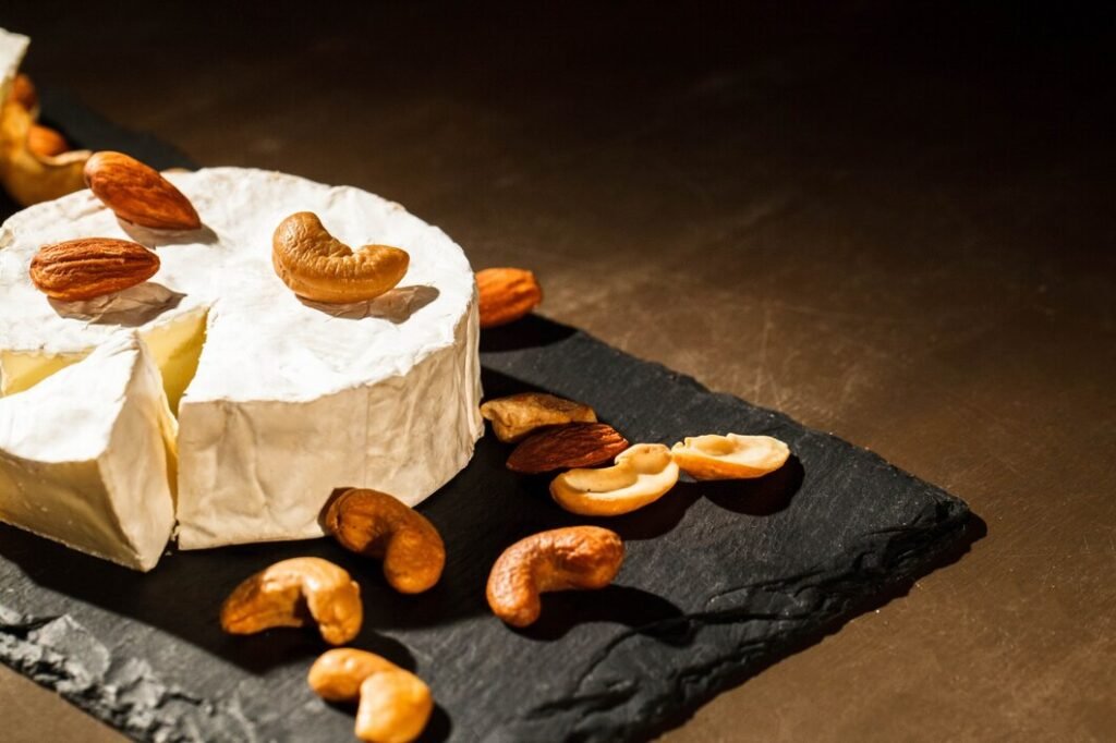diferentes tipos nozes mentira brie queijo pretas prato 1304 2857 Queijo brie com castanhas sobre uma tábua