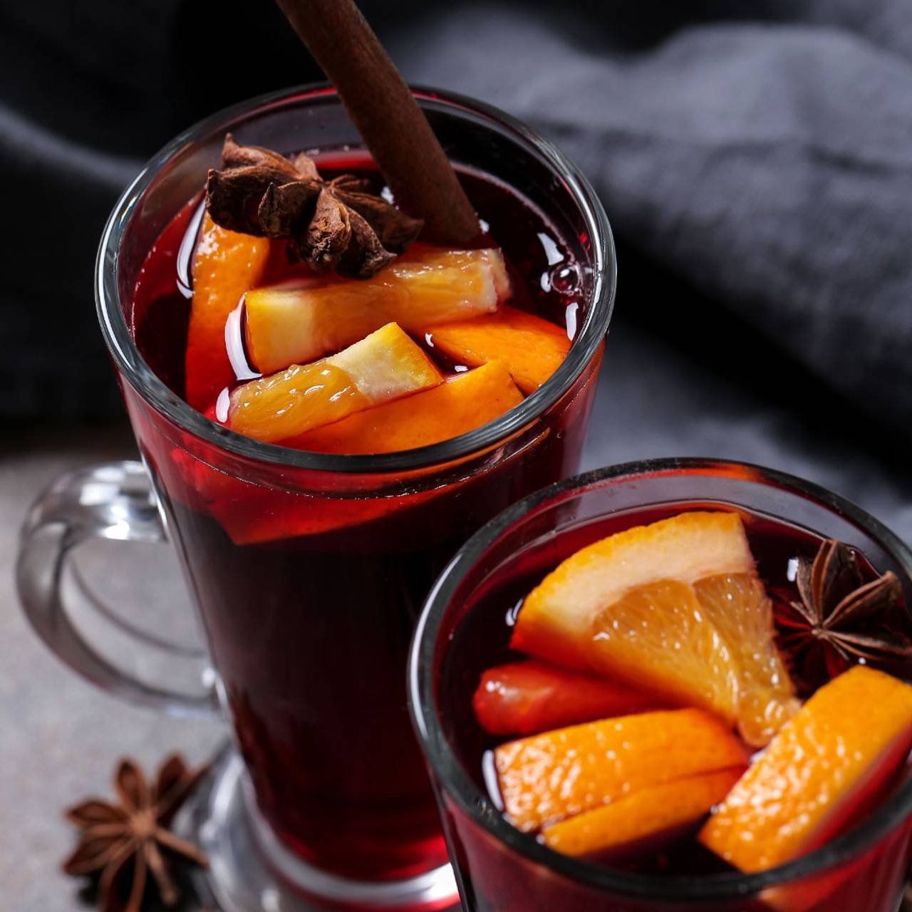 copos de vidro com quentão de vinho e pedaços de laranja 
