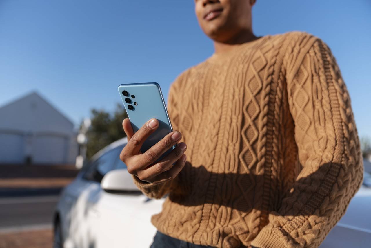 homem de vista lateral usando smartphone ao ar livre