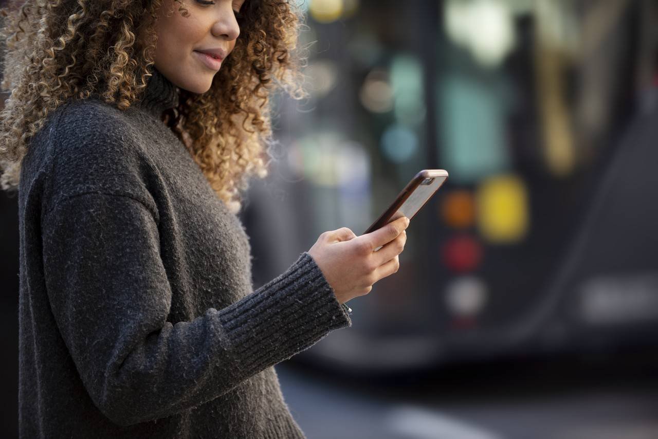 mulher verificando o telefone no meio da rua