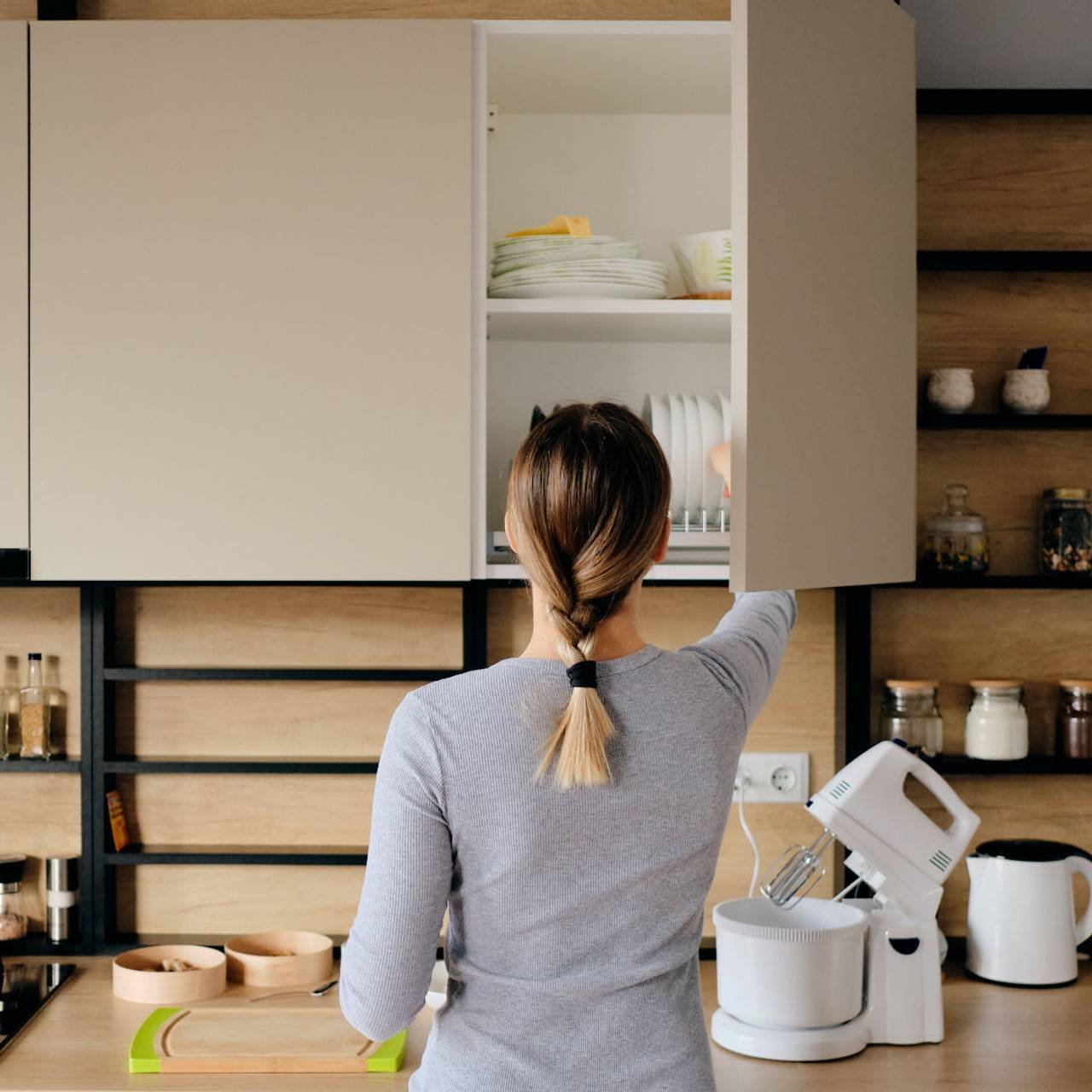 mulher em casa levando algo de uma loja de cozinha