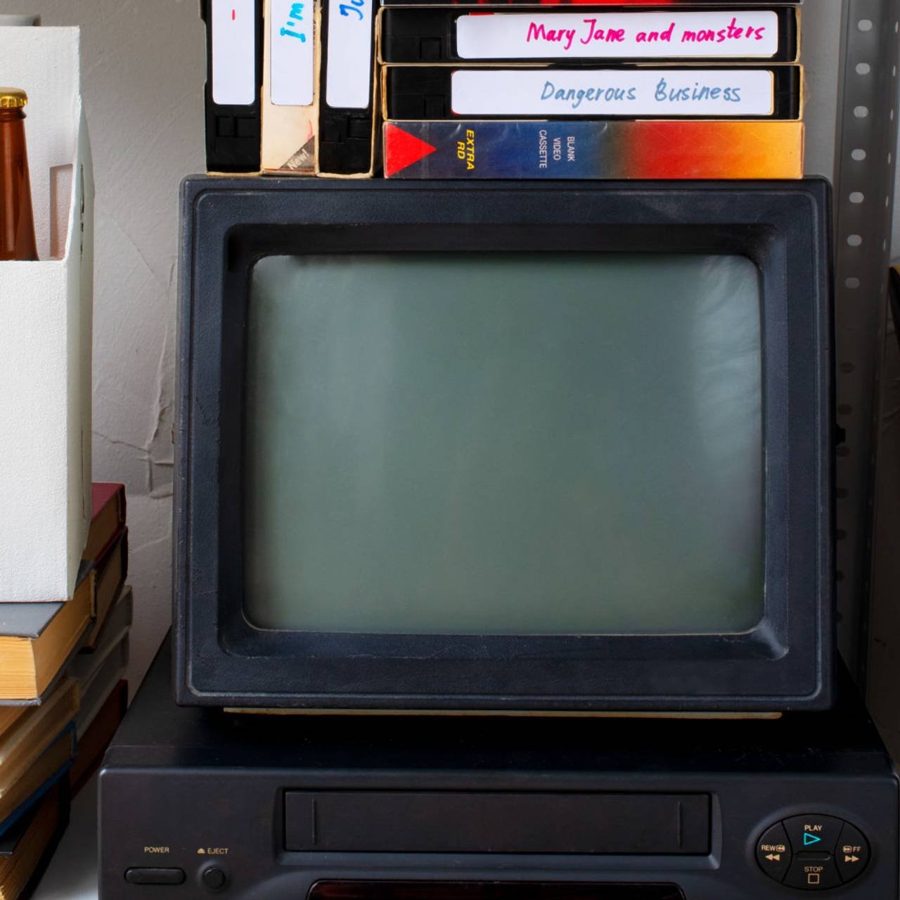 Televisor antigo com DVDs em cima 