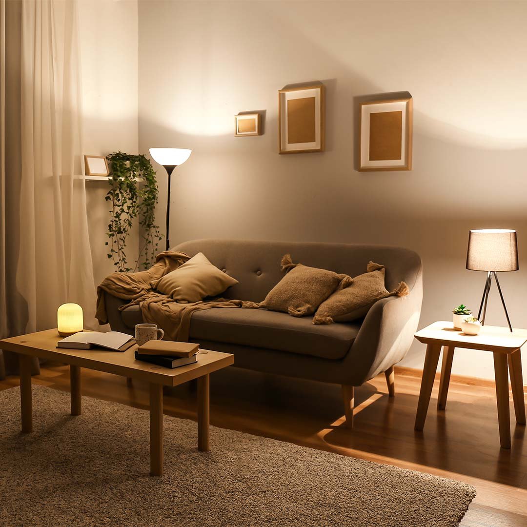 sala de estar com sofá claro, tapete, lanternas e pendentes