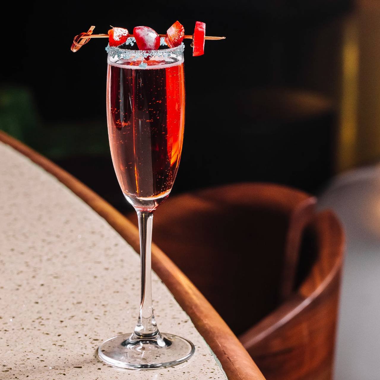 taça com drink manhattan e pedaços de cereja na borda