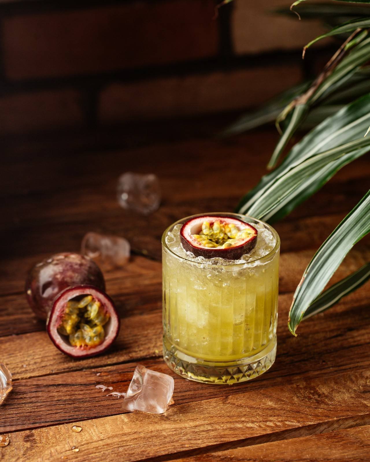 um coquetel de frutas com cubos de gelo na mesa de madeira