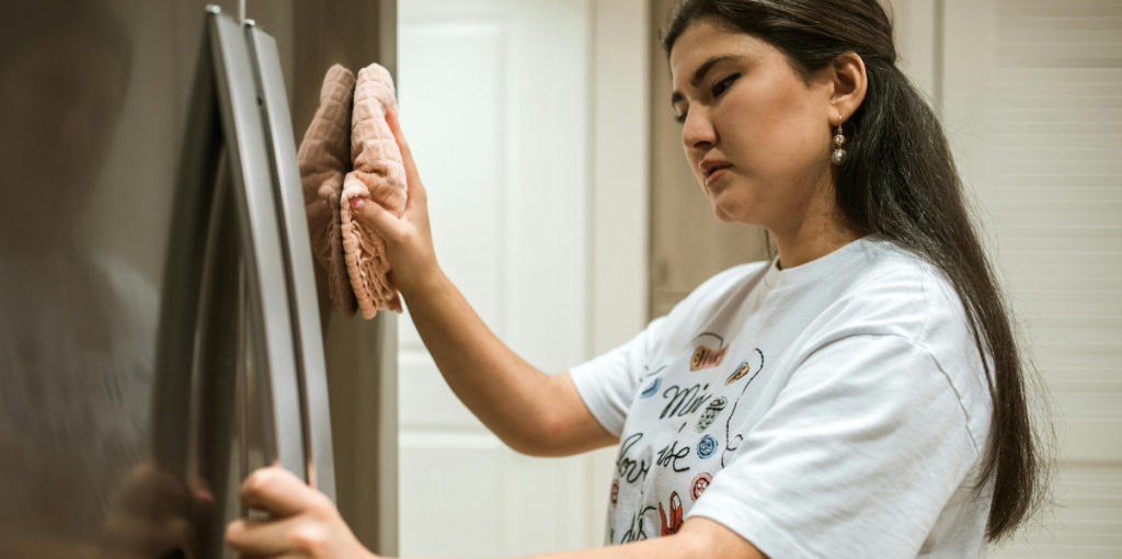 9 Mulher limpando refrigerador na cozinha
