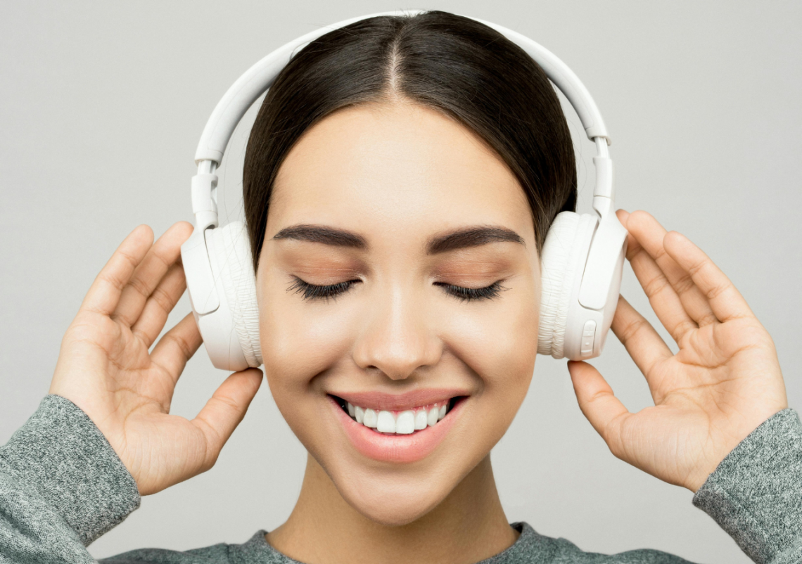 Modelodebullett.variadogrande11 Mulher sorrindo com fones de ouvido brancos