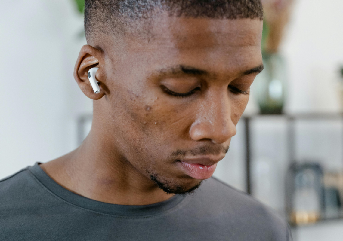 Modelodebullett.variadogrande12 Homem com fones de ouvido sem fio em ambiente moderno