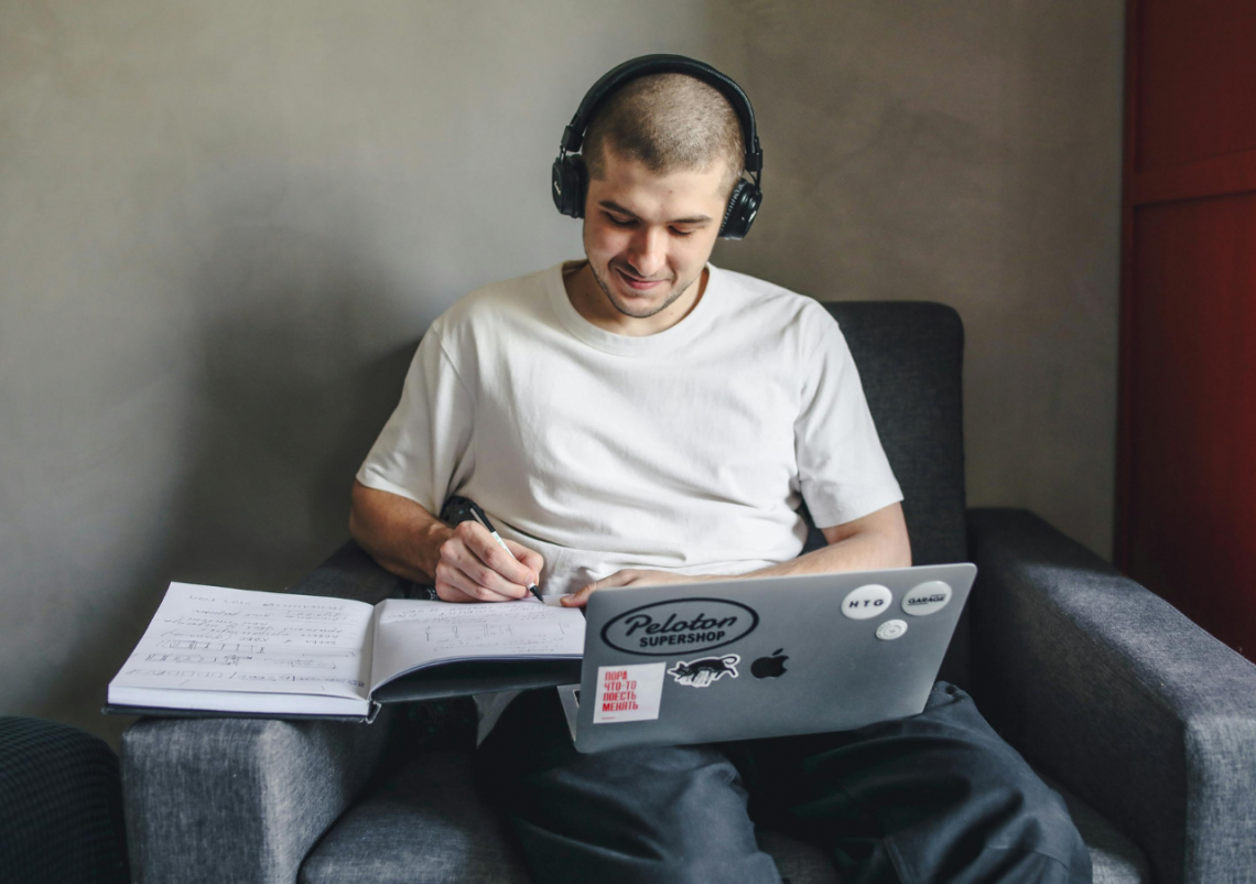 Modelodebullett.variadogrande14 Homem estudando com fones e caderno na cadeira