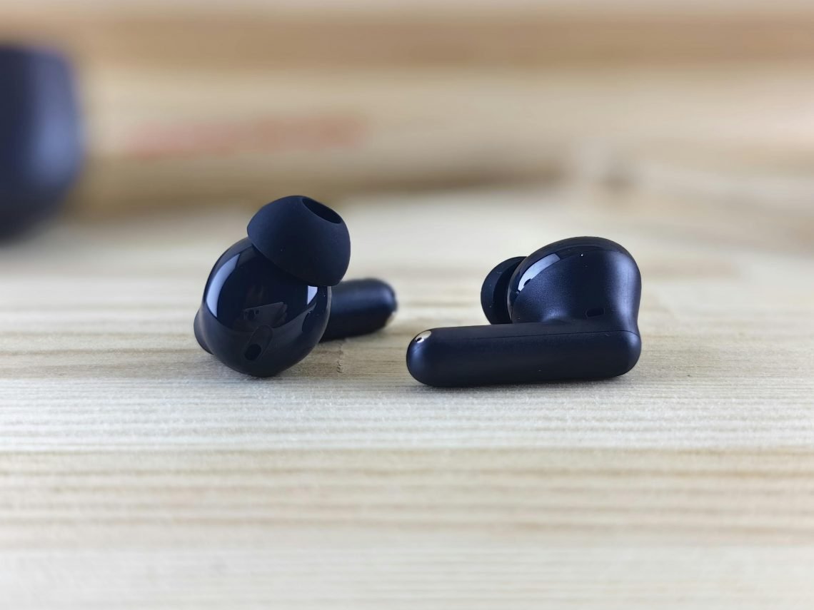 pexels zeleboba 28206207 Fones de ouvido sem fio pretos sobre mesa de madeira